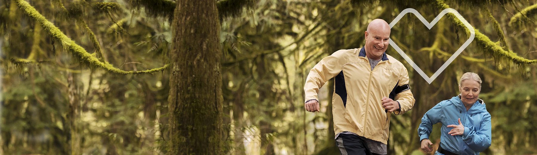 Senior couple jogging in the woods