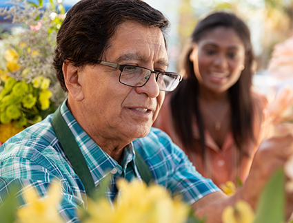 Shop owner arranging flowers as customer looks on